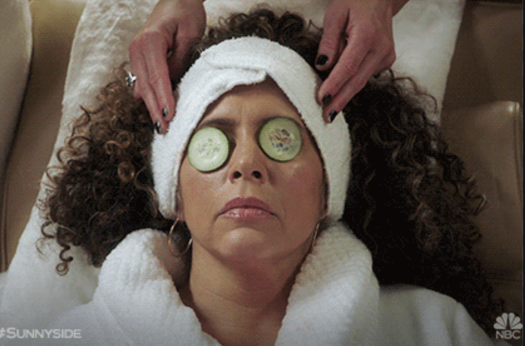woman with cucumbers on eyes getting head massage