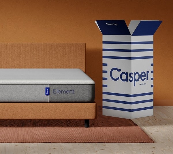 mattress on a bed frame with open Casper mattress box to the right