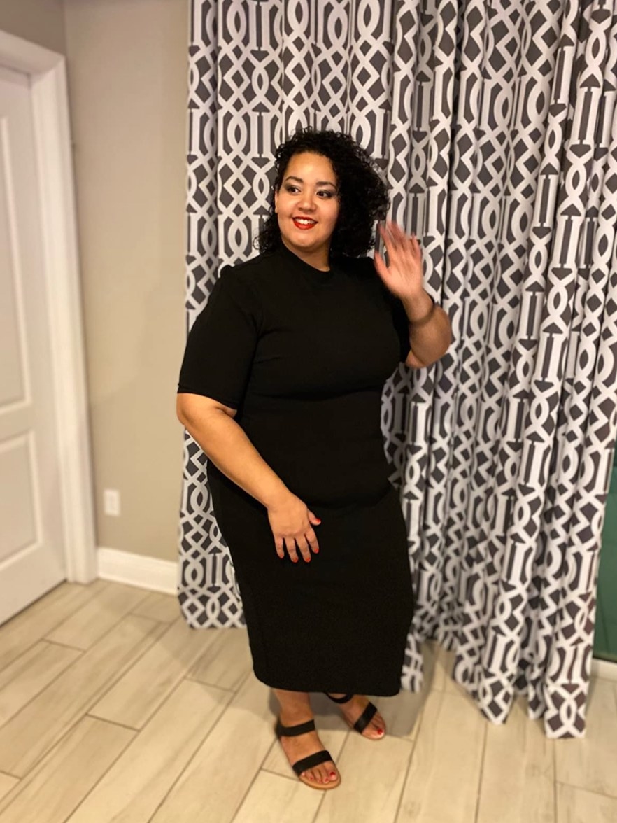 Reviewer wearing black midi short sleeve dress and sandals