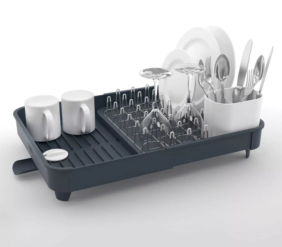 Gray extendable drying rack with dishes on it