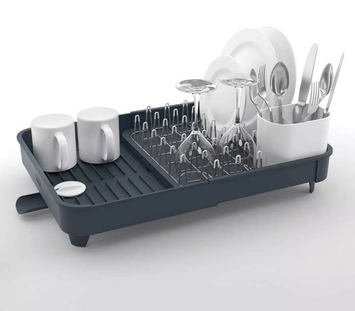 Gray extendable drying rack with dishes on it