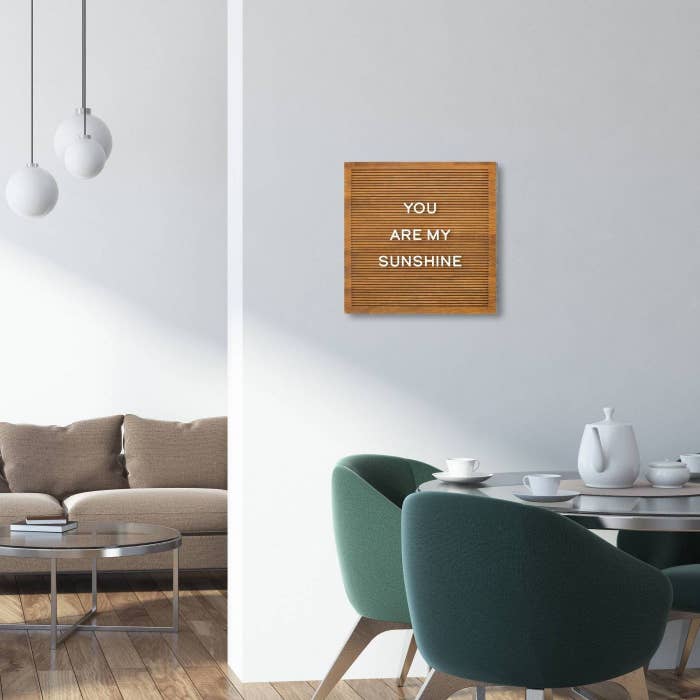 A wood letter board hanging on a wall in a dining room