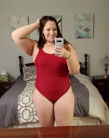 A reviewer wearing the suit in red 