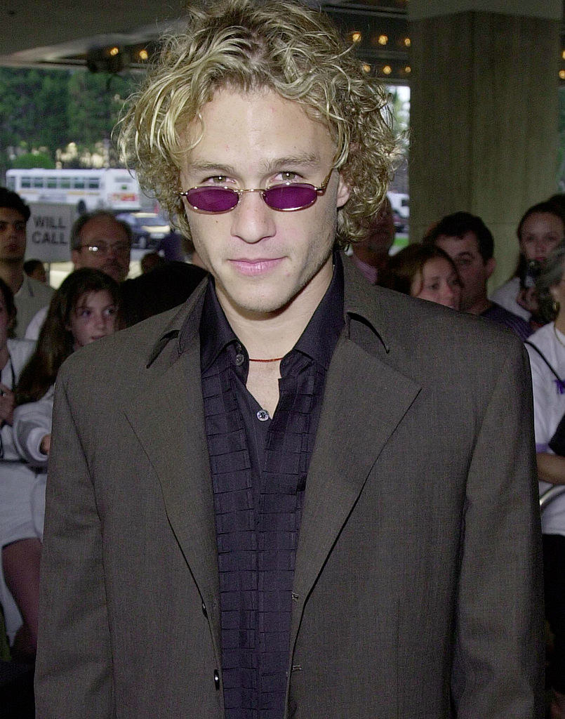 Heath Ledger attending a movie premiere; he is wearing a suit and purple-tinted sunglasses