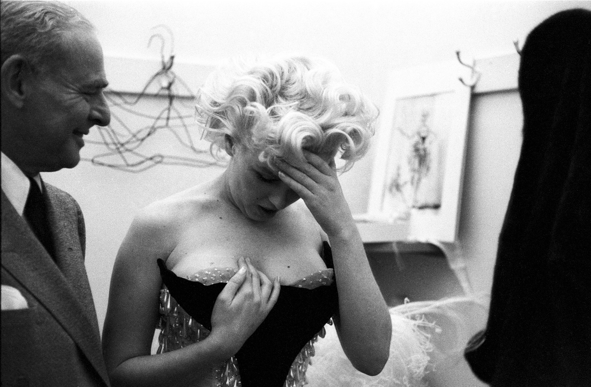 Marilyn Monroe looks down at her dress with her head on her forehand 