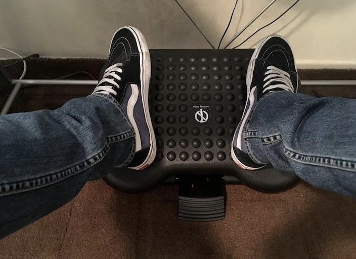 a reviewer showing the foot rest underneath their desk 
