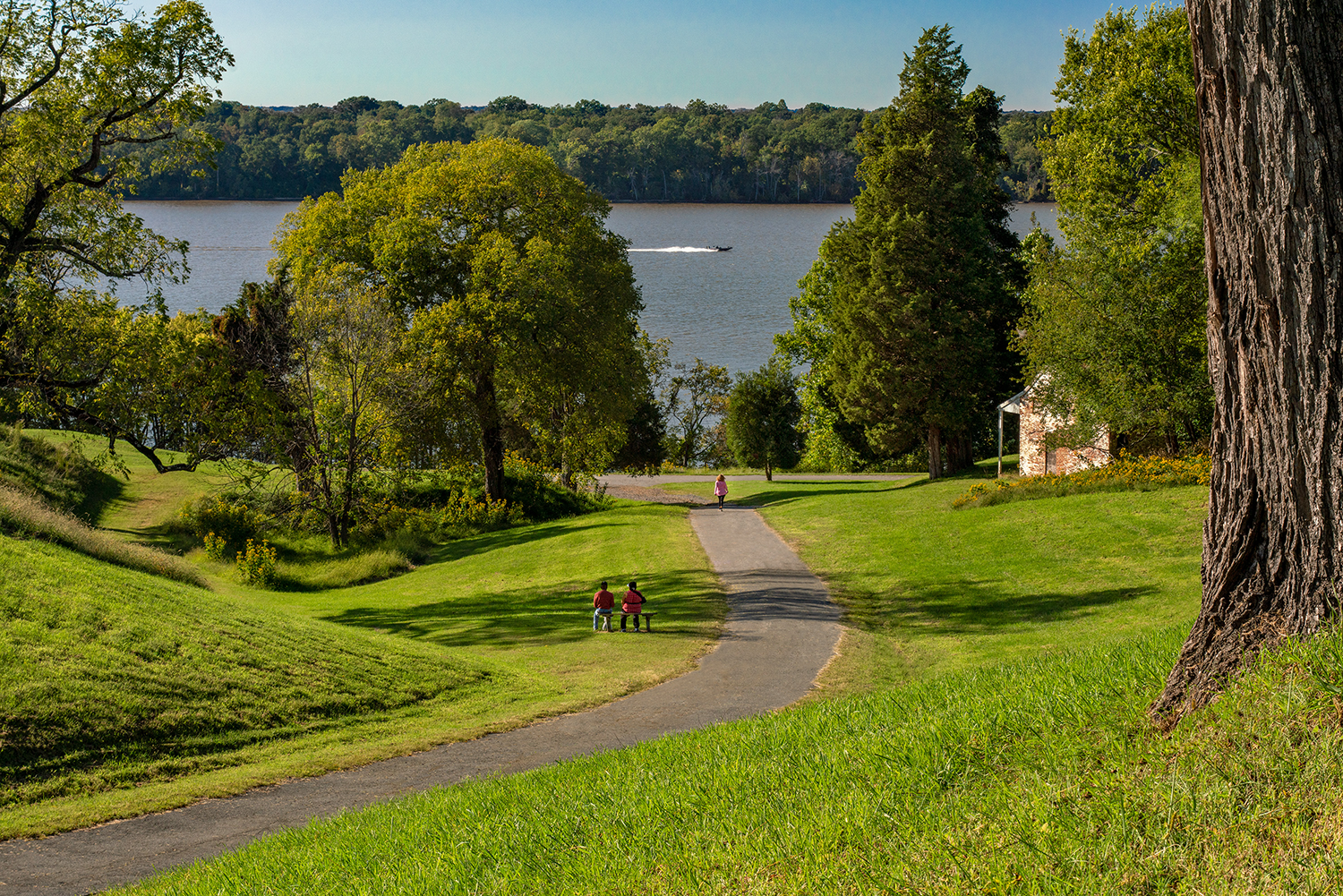 Two people lounging in front of a river