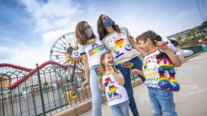 A family wearing Mickey, Minnie, Stitch, and Pixar shirts in rainbow patterns at Disney&#x27;s California adventure