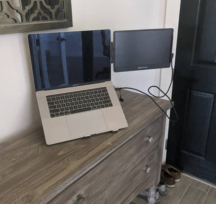 A reviewer photo of a laptop with a portable monitor attached to the side of it