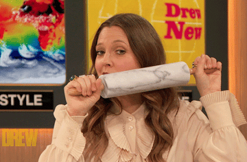 GIF of Drew Barrymore rolling a rolling pin over her face