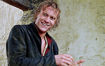 Heath Ledger smiling while he claps his hands together