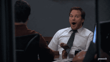 Gif of Andy from Parks and Rec looking happily surprised 