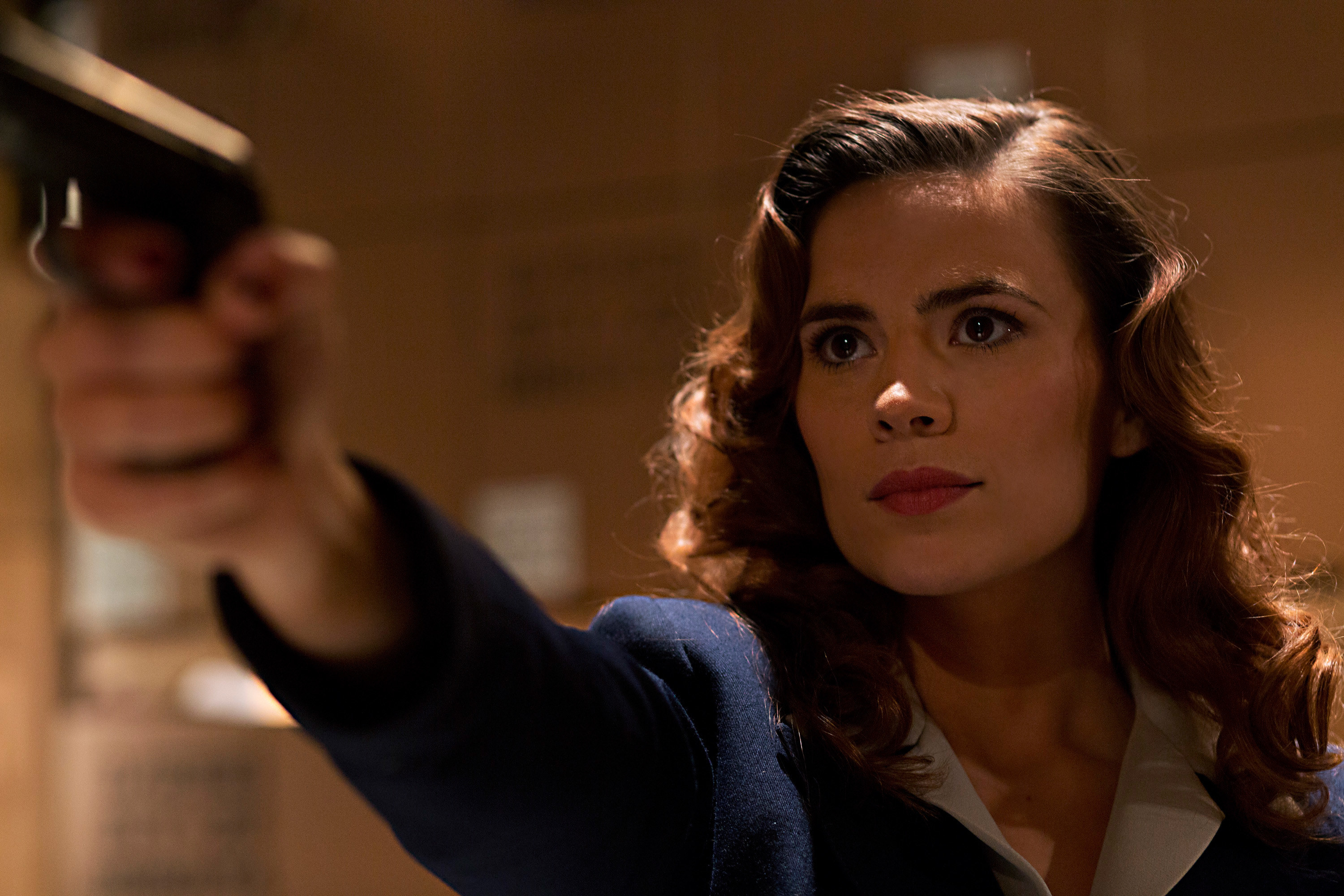 Hayley Atwell pointing a gun as Agent Carter