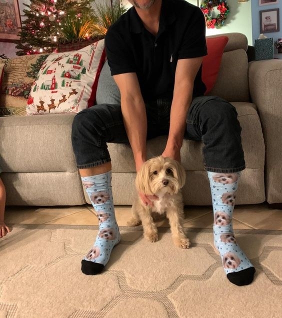 Reviewer wearing the socks that perfectly match his small dog