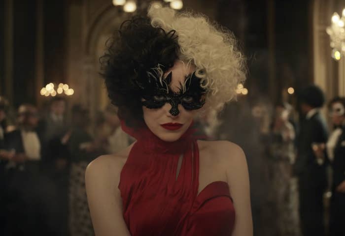 A screenshot from the movie of Cruella wearing a red gown