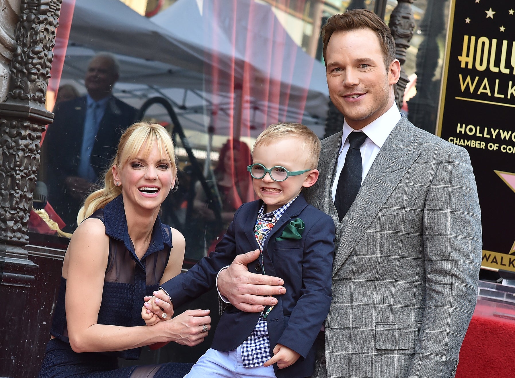 Chris and Anna hold hands with Jack at an event