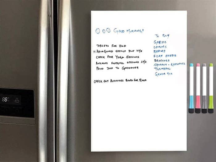 A dry-erase board with a list of things to-do stuck to a fridge with markers 