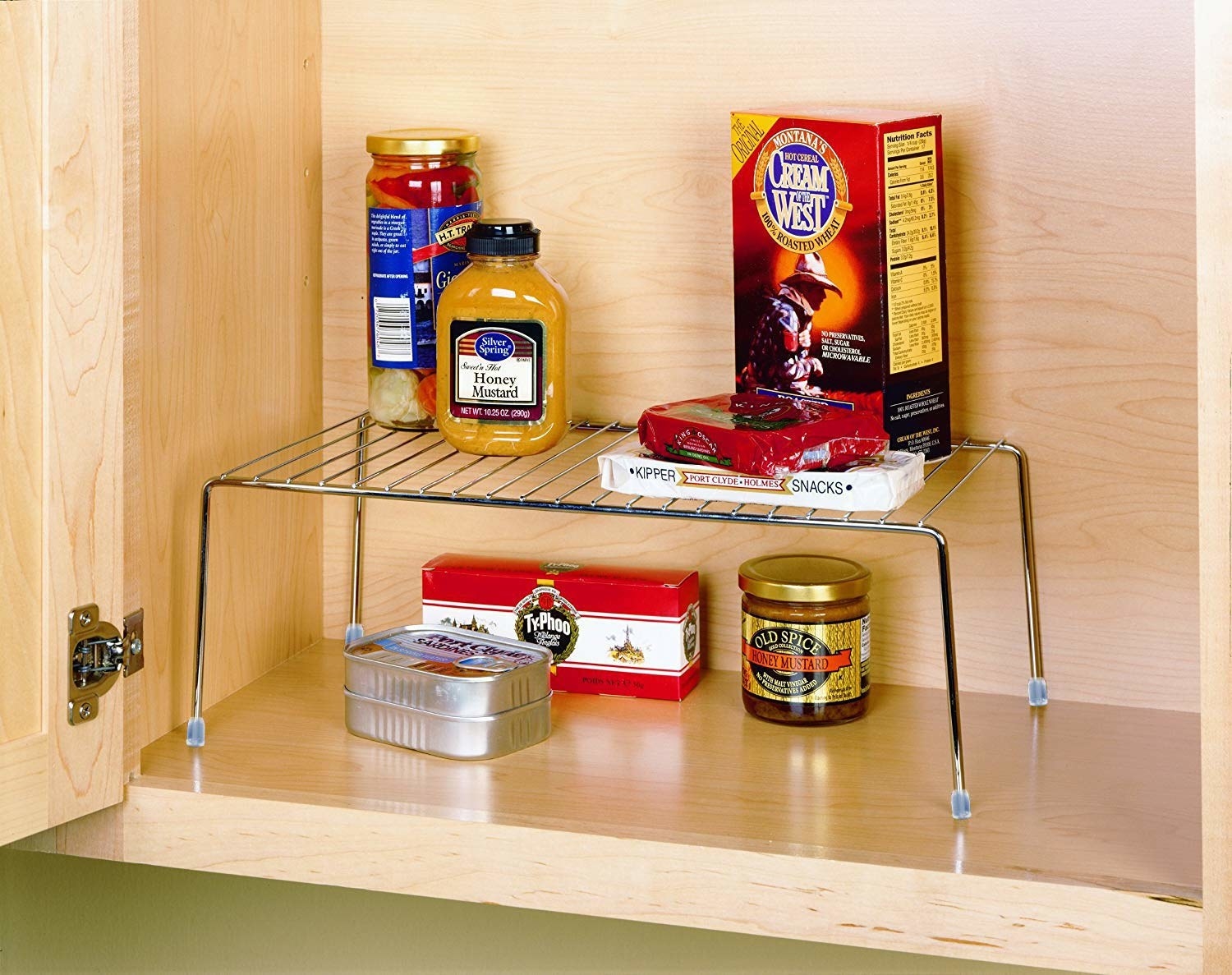 An expanding shelf rack in a cupboard with items on top and at the bottom of it