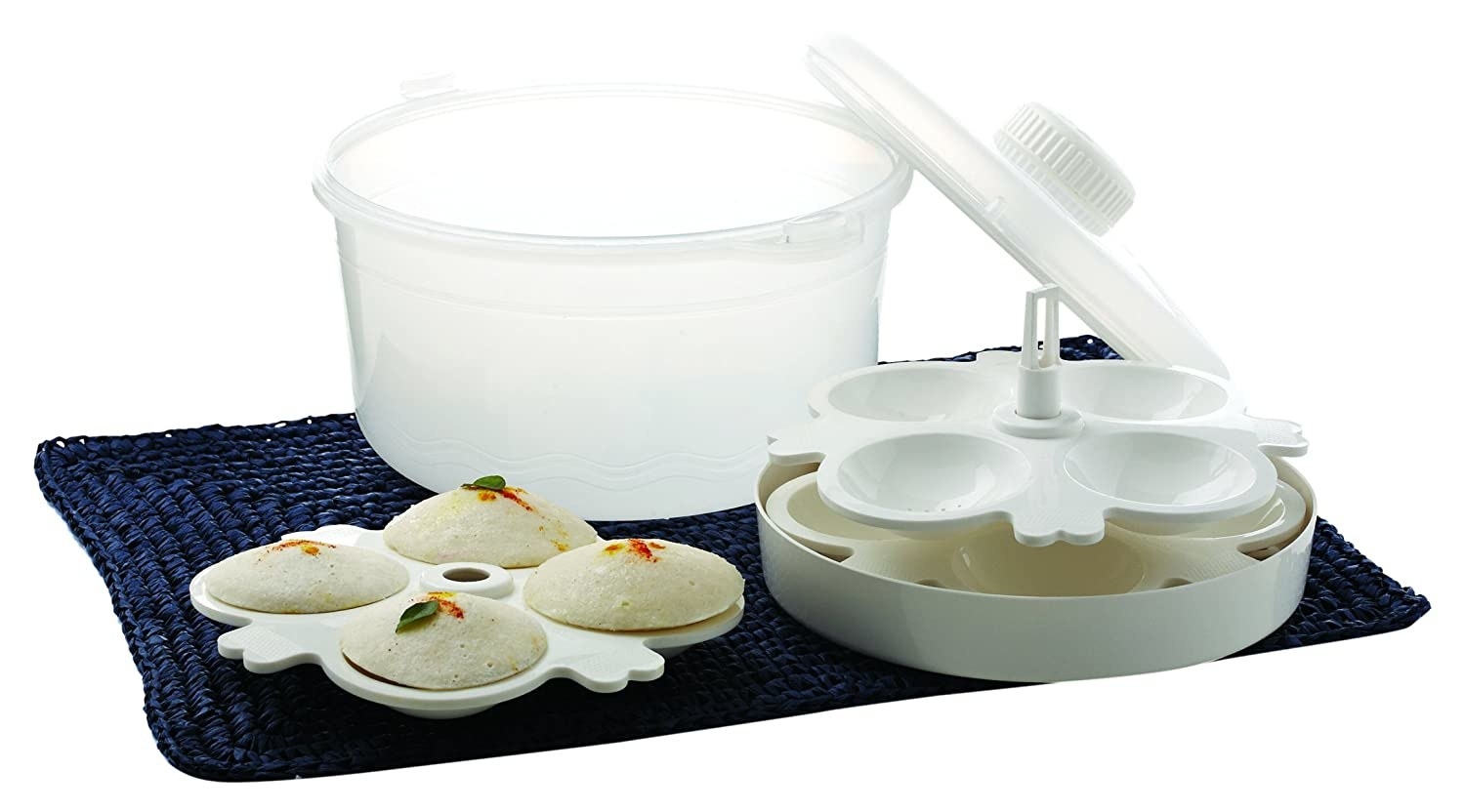 A microwave rice cooker with idlis in an idli plate 