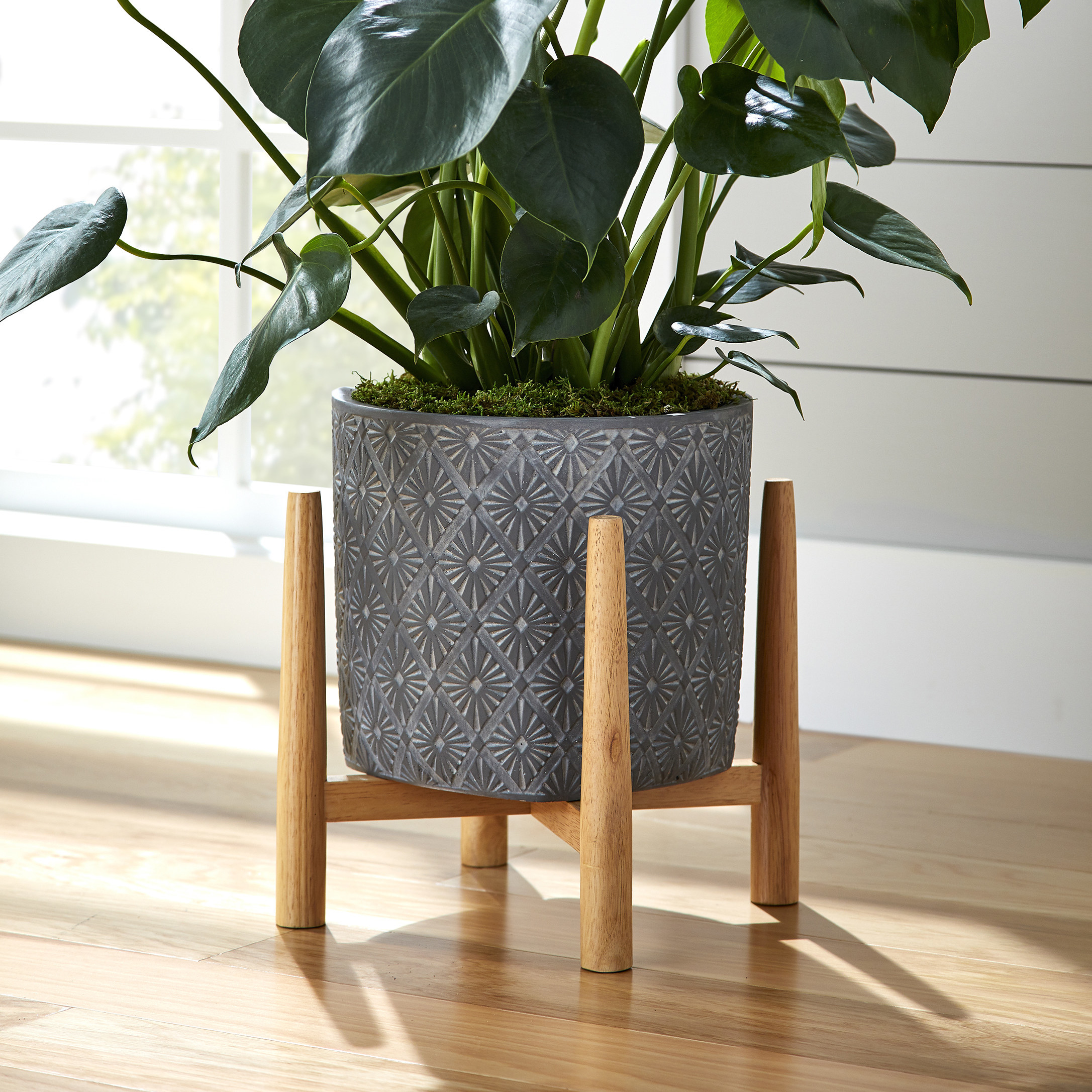 gray pot with geometric design and wooden stand
