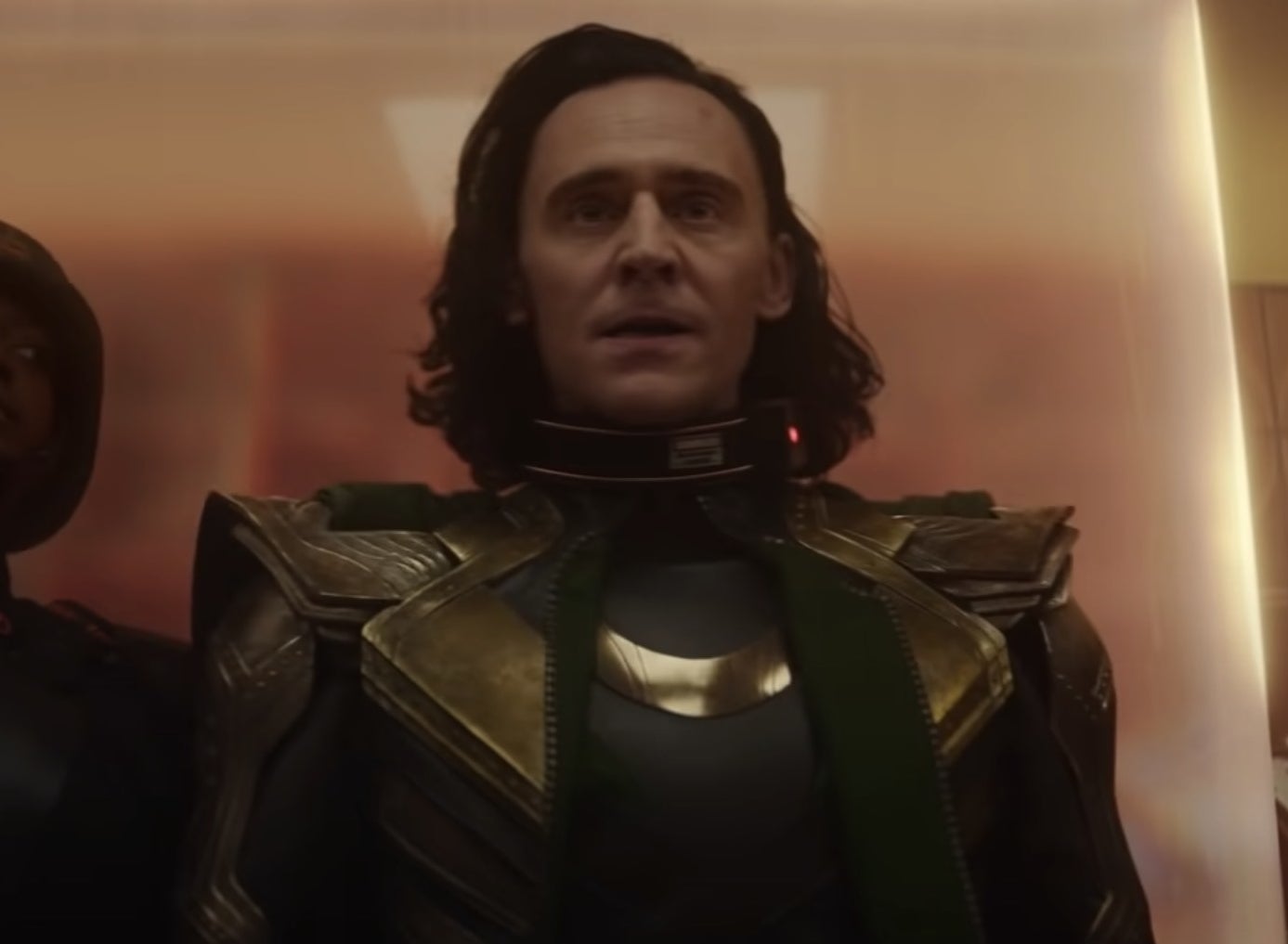 A screenshot of Loki being escorted into a building by a guard