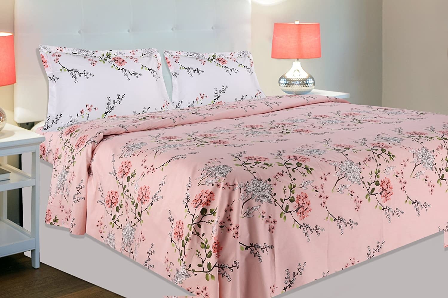 A pink and white floral bedsheet on a bed.