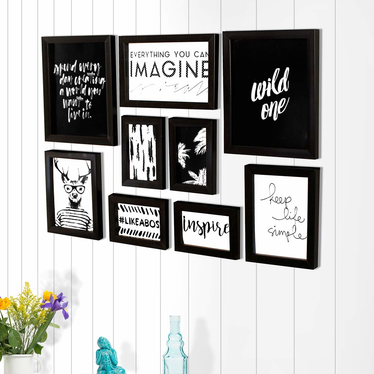 An assortment of framed black and white prints on a white wall.