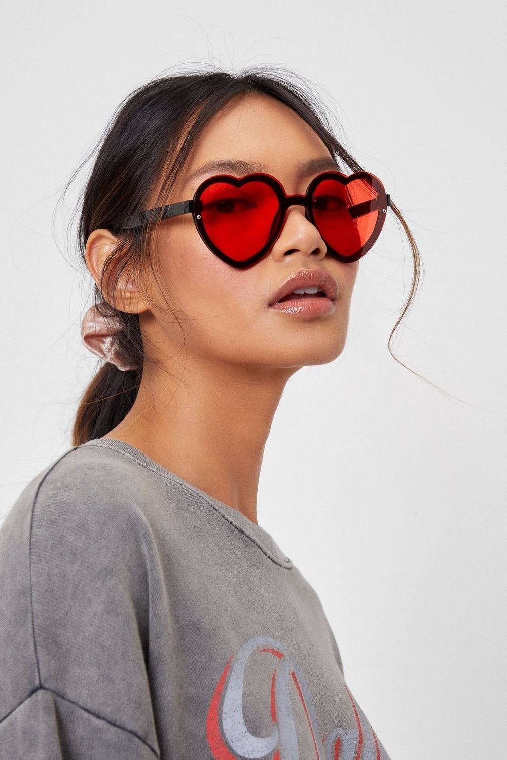 A person wearing large heart-shaped sunglasses