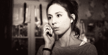 Troian Bellisario lifts a phone away from her face and mouths, &quot;What?&quot;