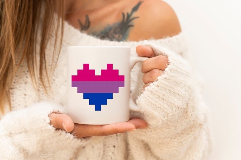 white mug with heart filled with bisexual flag colors inside