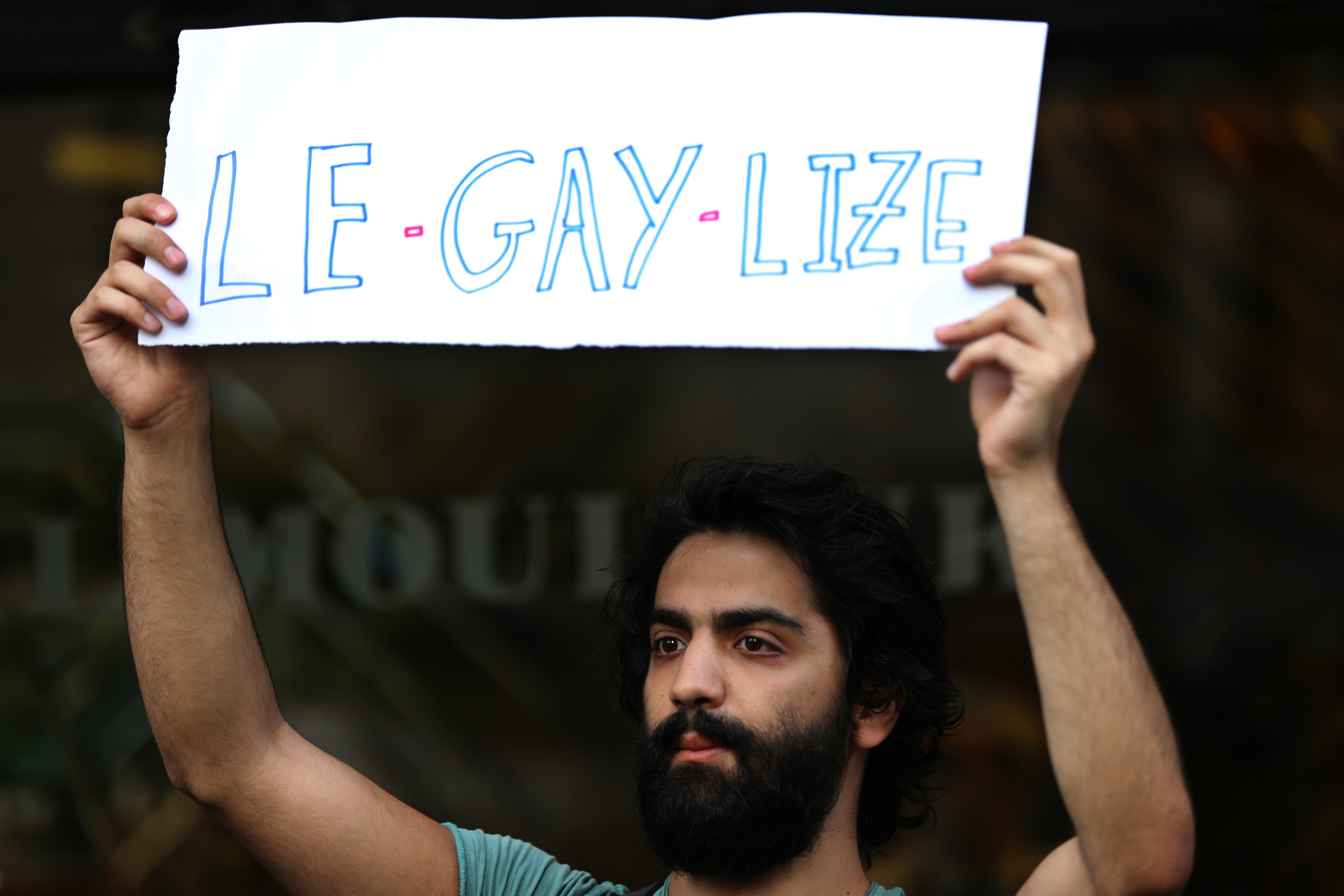 A protester holds up a sign that says &quot;Le-gay-lize&quot;