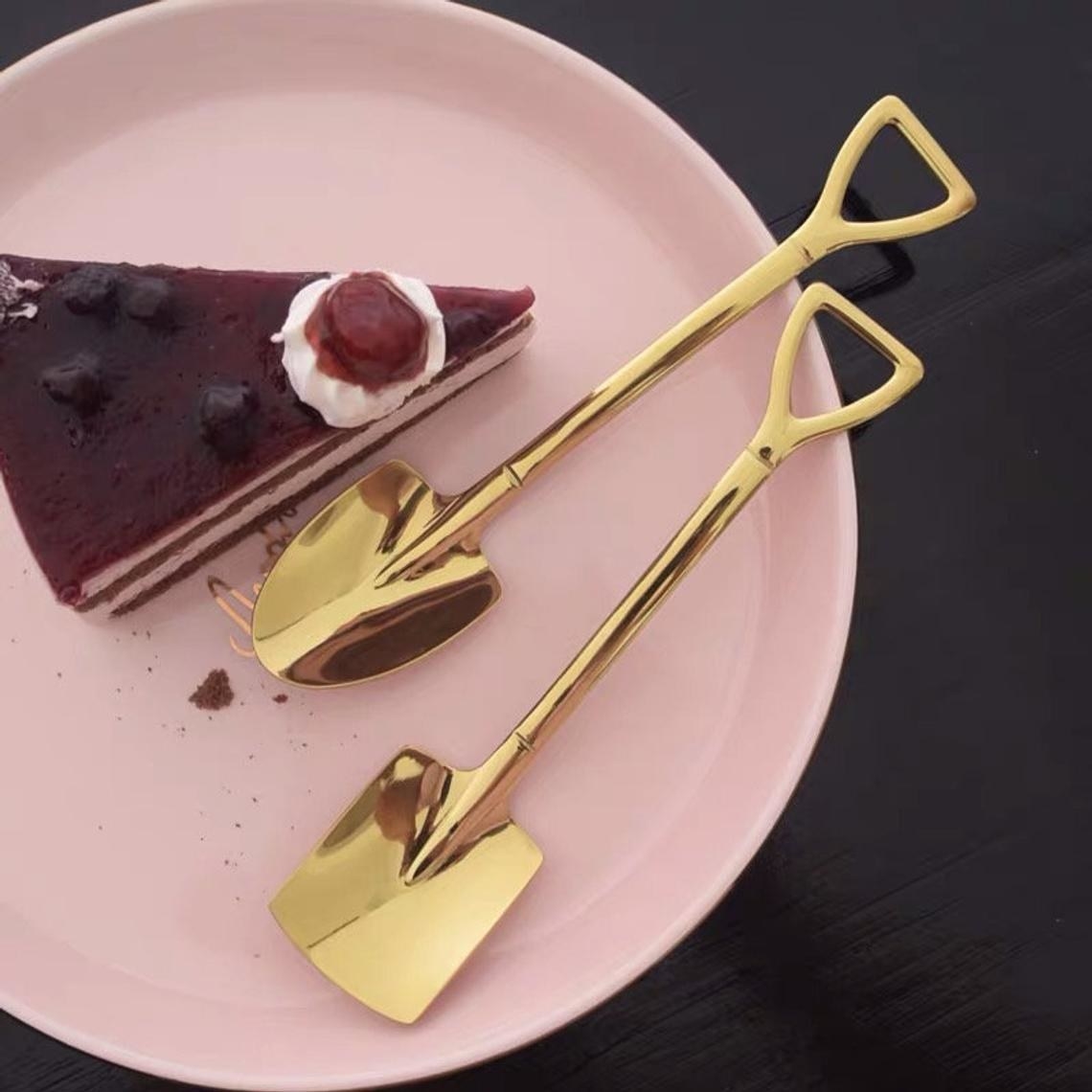 Two shovel spoons next to a slice of cake