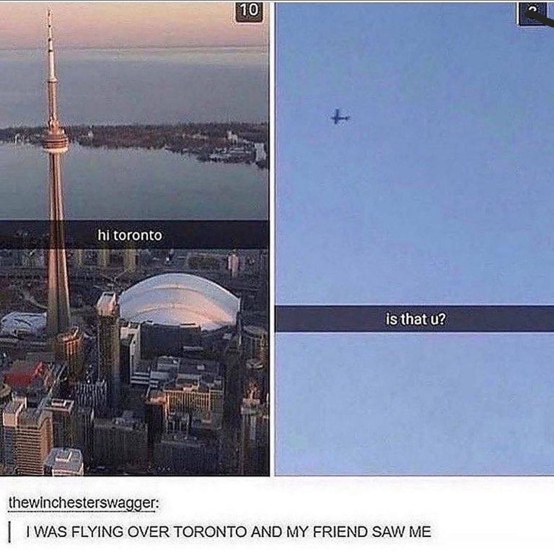 person flyiing over toronto while their friend on a ground takes a picture