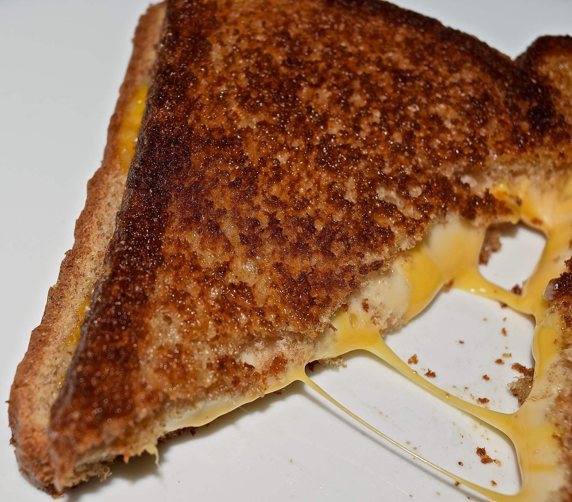 Half of a gooey grilled cheese sandwich