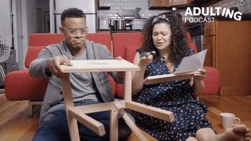 Two people struggling to build furniture on their floor