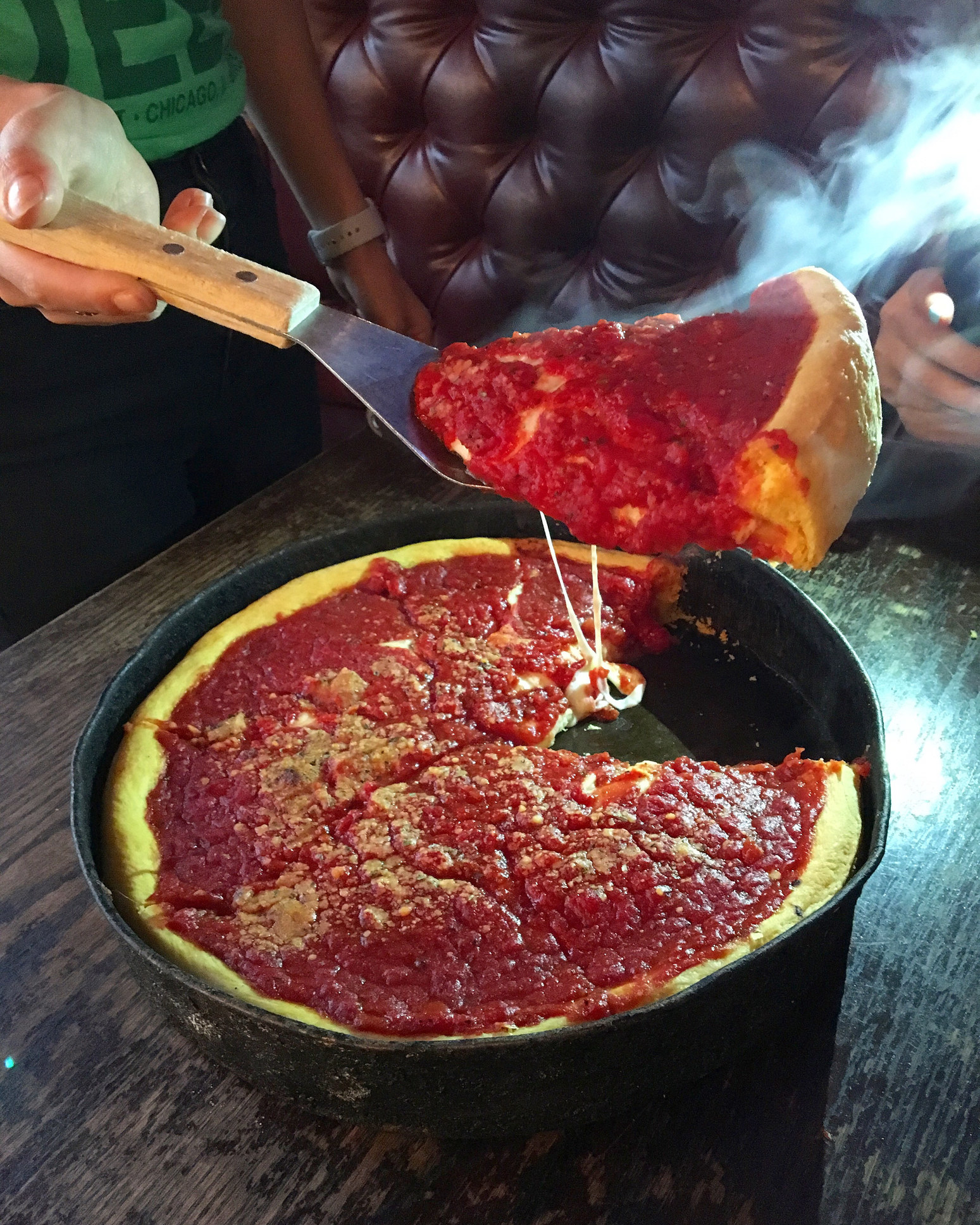 Taking a slice of deep dish pizza from the pan