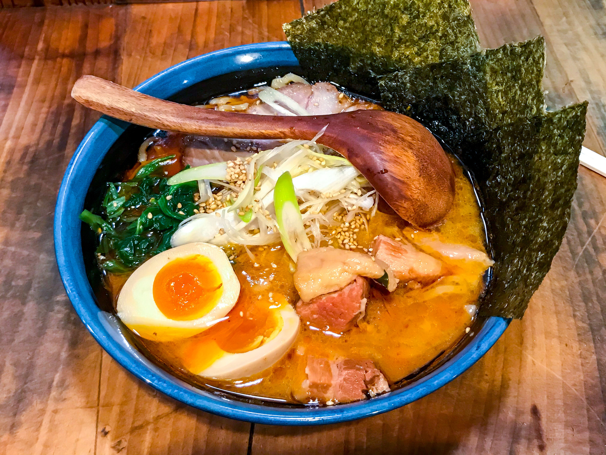 A bowl of ramen with a soft-boiled egg and seaweed