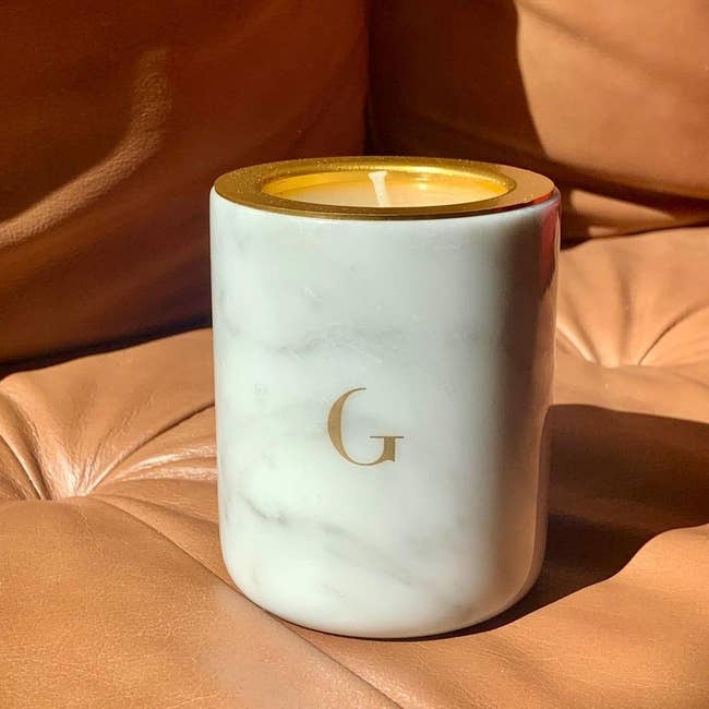 white marble candle sitting on a leather chair