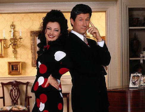Fran wears a black and white polka dot dress while standing back to back with her on screen husband