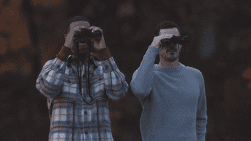Two people spying on others with binoculars