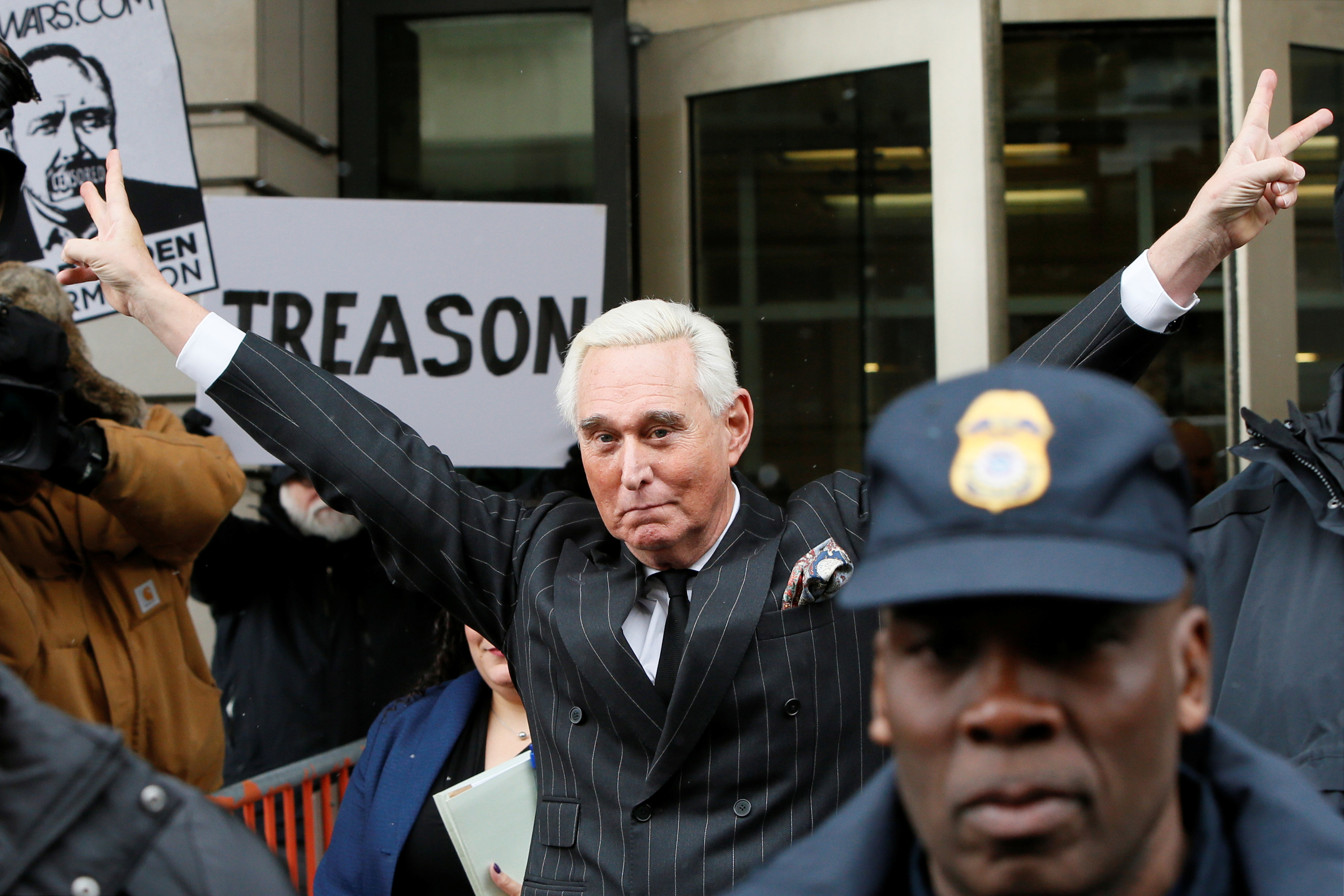 Roger Stone holds up two peace signs