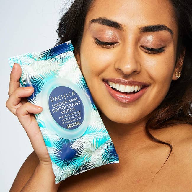 Model holding package of Pacifica Underarm Deodorant Wipes