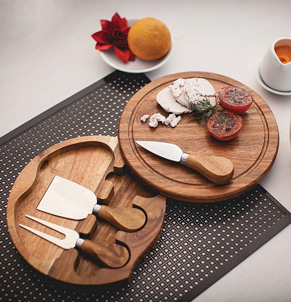 A split cheese board with three utensils in the bottom half