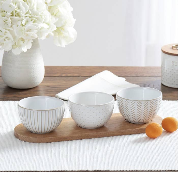 The three white bowls have stripes, dots and chevron patterns. 