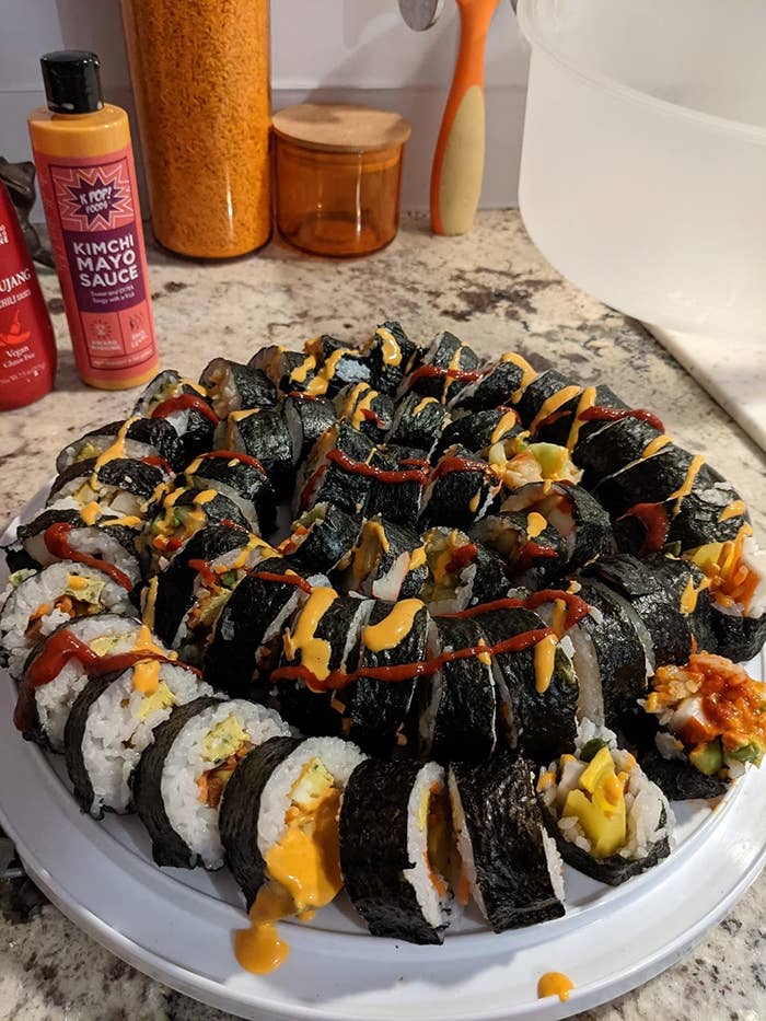 the bottle next to a big plate of homemade sushi 