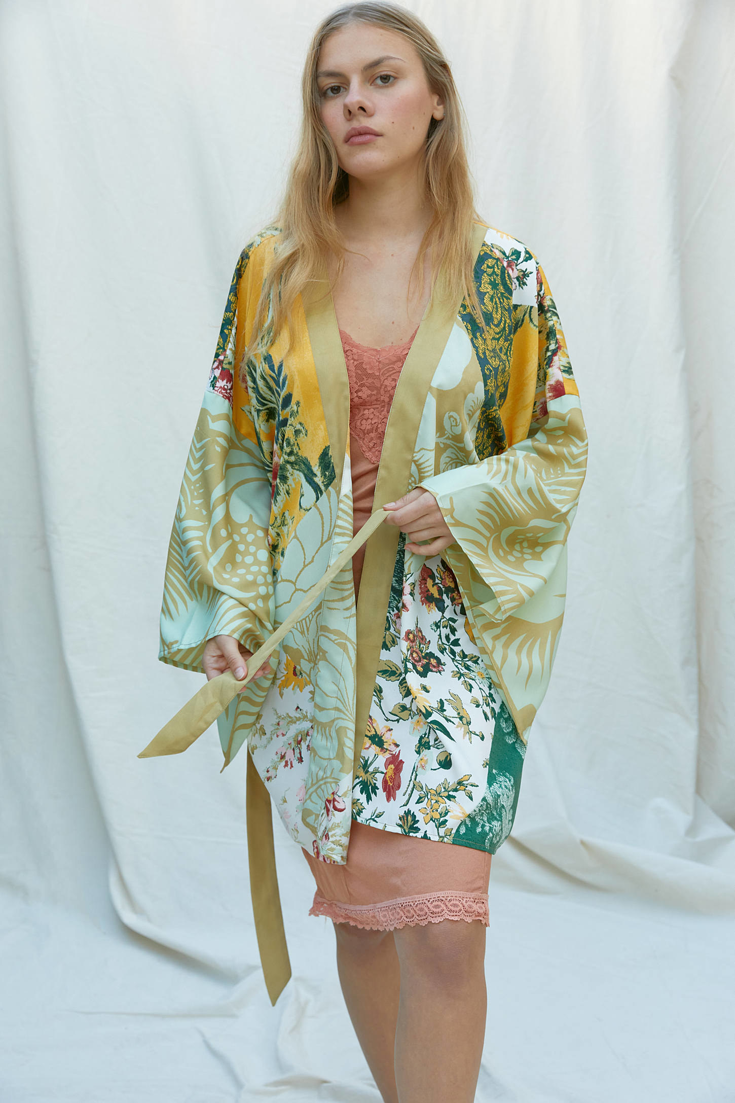 A model wearing the green floral robe over a slip dress 