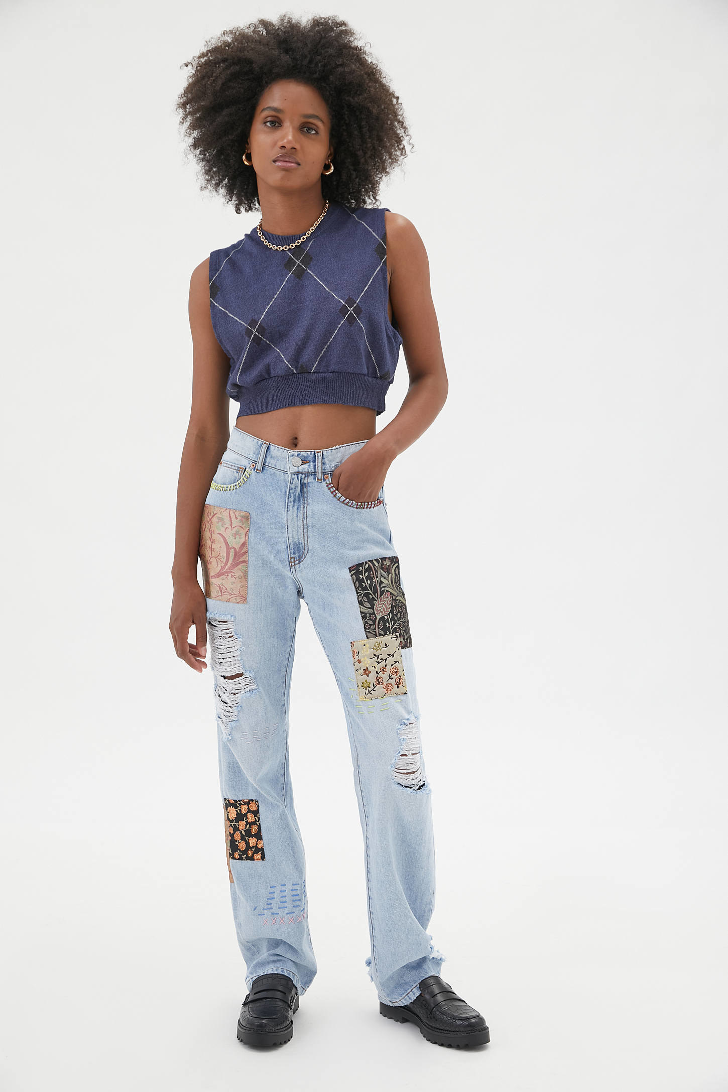A model wearing the jeans with printed patches and rips