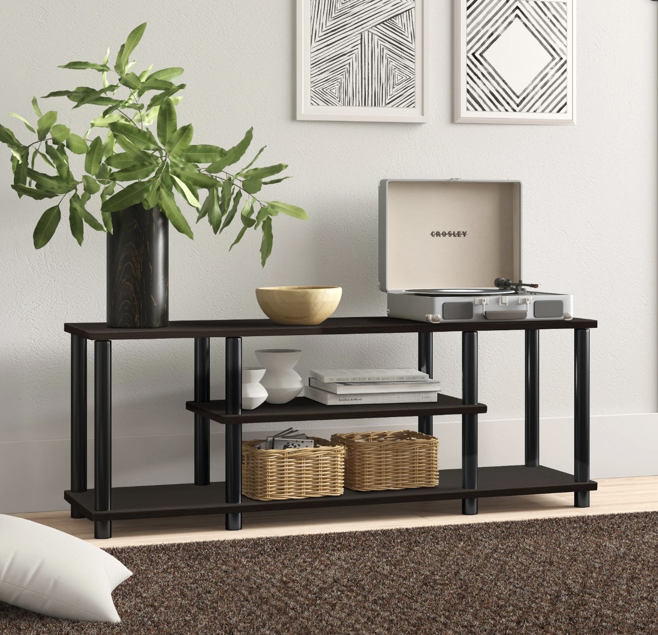 A black open shelve TV stand with a plant and record player on top