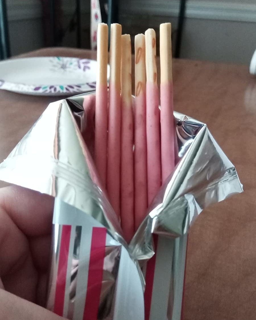 A reviewer holds an open pack of the cookies