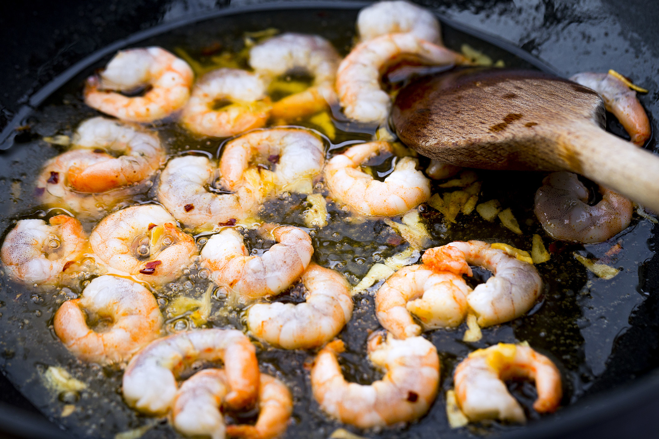 Garlic frying in oil with shrimp.